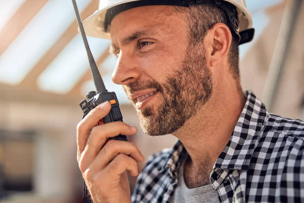 Fiatal férfi építész kommunikál egy walkie-talkie — Stock Fotó