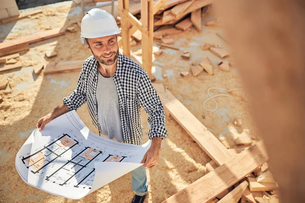 Trabalhador qualificado do estaleiro de construção com uma planta de uma casa — Fotografia de Stock