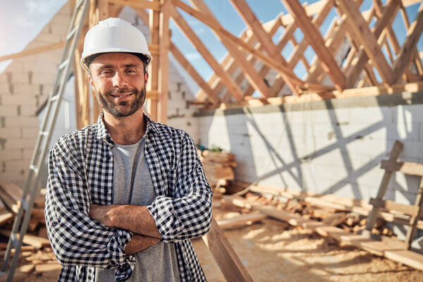 Gladsome architect posing proudly at a construction in progress