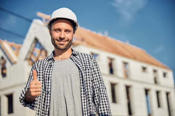 Ικανοποιημένος νεαρός αρχιτέκτονας που είναι ευχαριστημένος με το αποτέλεσμα του κτιρίου — Φωτογραφία Αρχείου