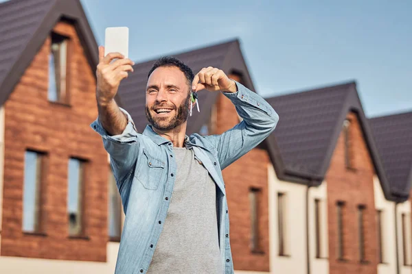 Aufgeregter Mann fotografiert sich mit Schlüssel — Stockfoto