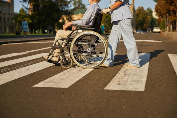 Дружелюбные люди, гуляющие на инвалидной коляске по городу — стоковое фото