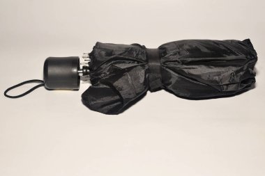 Siyah erkek şemsiyesi yürüyüş için katlanmış.