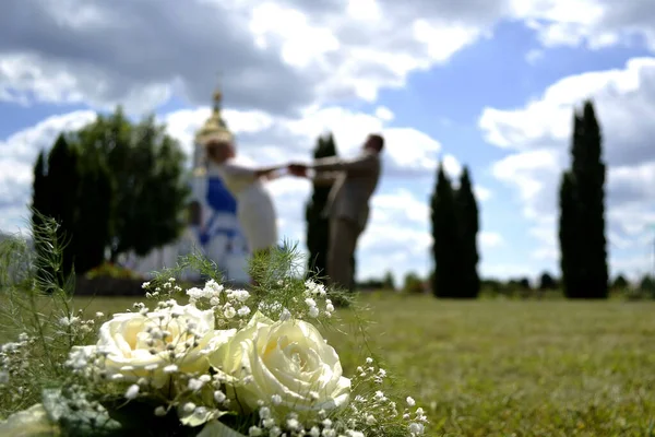 幸せな恋人を背景に結婚式の花束 — ストック写真