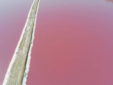 İran, Şiraz yakınlarında Maharlu pembe tuz gölü. İran 'daki Shiraz yakınlarındaki tuz fabrikasının hava aracı görüntüsü. Yosun ve plankton kolonisinden kaynaklanan pembe su.