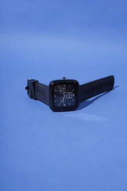 Mavi arkaplanda siyah bir saat var.