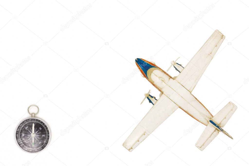 Still life with a scale model of a  plane and compass. Travel concept. Top view travel or vacation concept. Traveler accessories on a white background with blank space for text. 