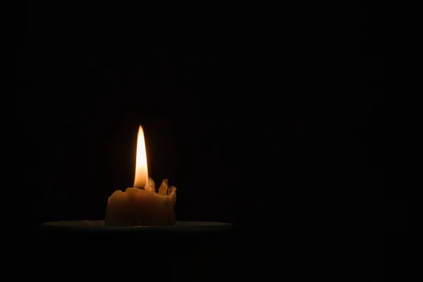 Siyah seramik bir tencerede koyu bir arka planda yanan mum. Kehanet, büyü, ritüel kavramı. Boşluğu kopyala.