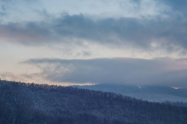 Akşam gökyüzünün arka planında karlı dağ.