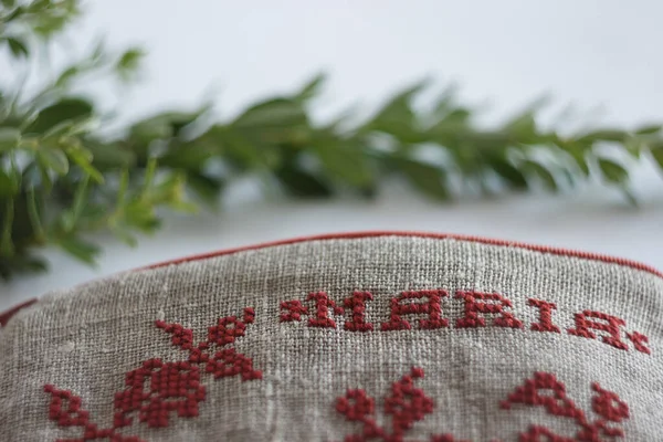 Makeup bag made from linen cloth and embroidered with red threads. Personalized wristlet bag. The small depth of field.