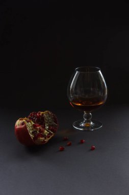 Bir bardak konyak ve nar. Teşekkürler. Durgun hayat. Koyu arkaplan.