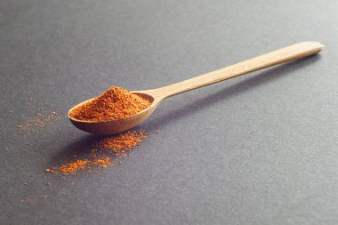Acı biberli ahşap kaşık. Koyu arkaplan .