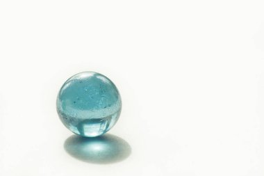 Beyaz arka planda mavi renkli cam top. Uzayı kopyala Soyut arkaplan. Yüzeyin derinliği (DOF)