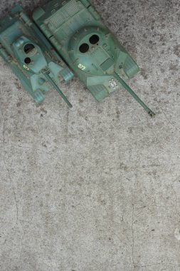 Beton arkaplandaki tankları ölçeklendir. Oyuncak. Geçmişi. Boşluğu kopyala