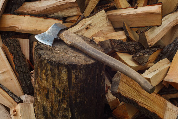 Ax in the background of firewood. The place for the felling of firewood. Close-up