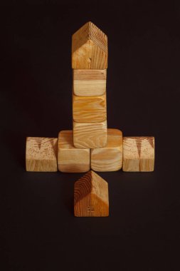 Çocuklar için tahta yapı taşları. Koyu arkaplanda tahta küplerden yapılmış oyuncak binası