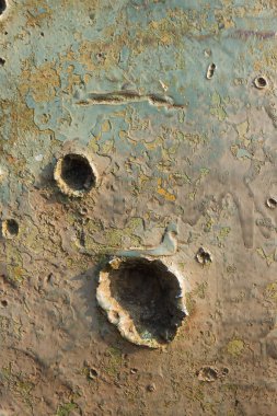 Tankın yeşil renginin eski askeri yardım dokusu. Zırhlı askeri araçta kurşun ve şarapnel izleri var.