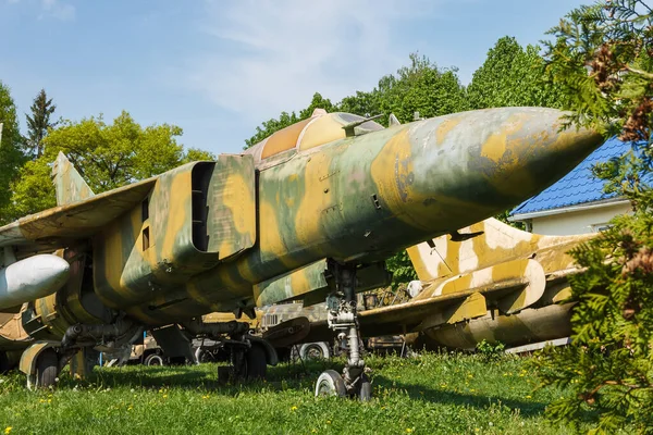 Bitkiler arasında eski bir jet uçağının gövdesinin parçası. Terk edilmiş askeri teçhizat parkı