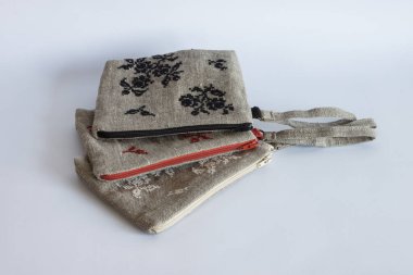 Keten kumaş ve nakışlardan yapılmış makyaj çantaları. Hafif arkaplan ve nakış.