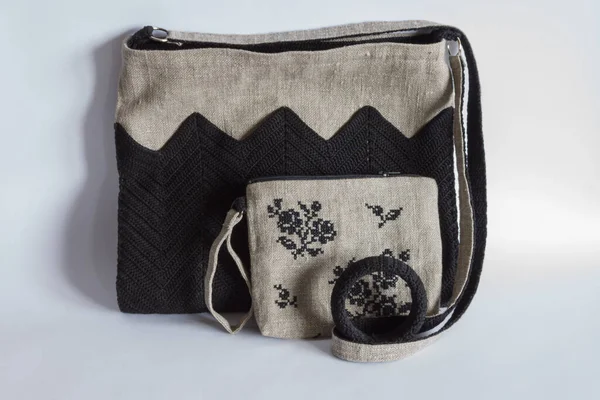 Crossbody bag, makeup bag and bracelet. Linen bag. Knitted black decor. Light background