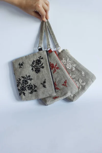 Makeup bags made from linen cloth and embroidery. Light background.and embroidery