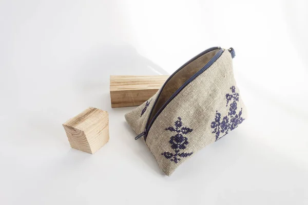 Linen cosmetic bag with a blue embroidery. Light background