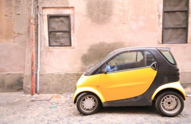 Roma İtalya - 18 Haziran 2019: Roma İtalya şehir merkezinde dar sokakta park edilmiş küçük araba