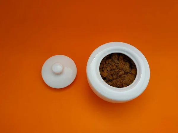 Turuncu arka planı olan güzel beyaz şeker kasesi.