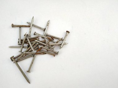 Beyaz zemin üzerindeki çelik çivilerin farklı görünümleri