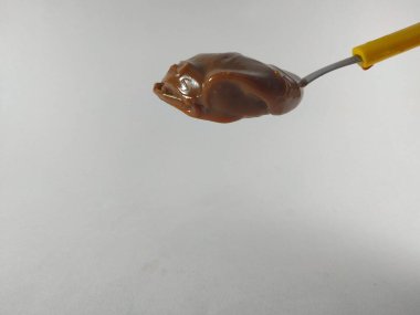 Sarı kaşıkta fıstık ezmesi.