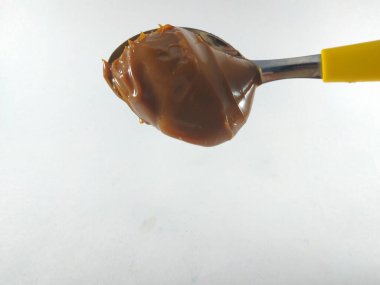 Sarı kaşıkta fıstık ezmesi.