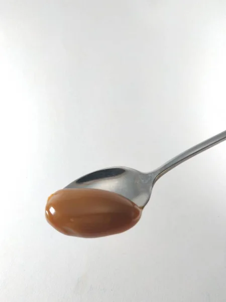 Sarı kaşıkta fıstık ezmesi.