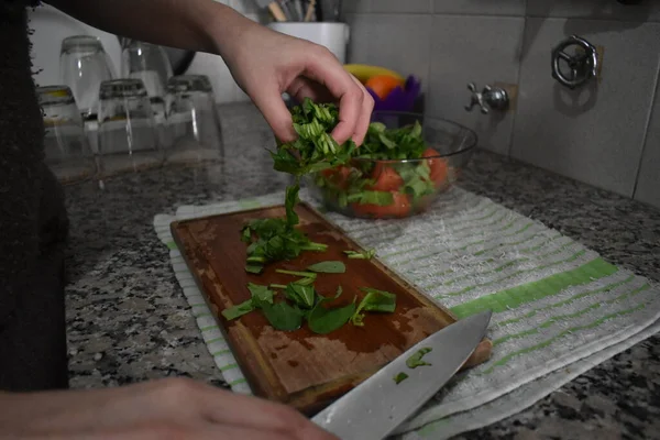 Ispanak kesen ve salata yapan kadın.