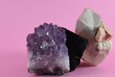Pembe arka plana yerleştirilmiş mineraller ve kayalar