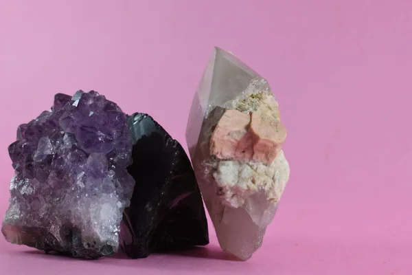 Pembe arka plana yerleştirilmiş mineraller ve kayalar