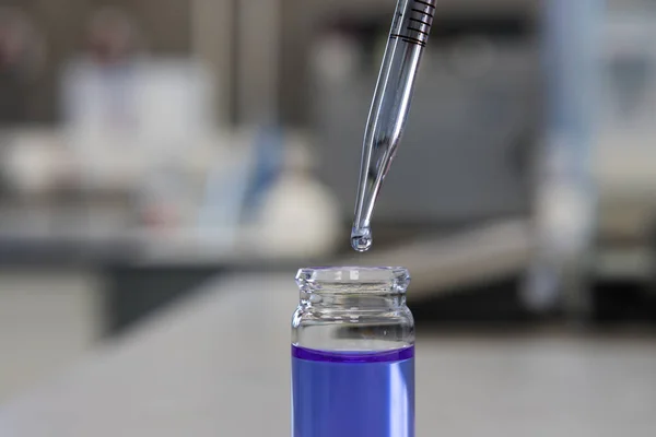 Purple chemical solution and a pipette in a science laboratory. Analytical chemistry