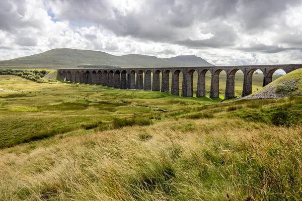 Yorkshire Dales 'de Ribblehead viyadük. Carlisle demiryolu yerleşim yerindeki büyük taş köprü geniş bir vadiden geçiyor.