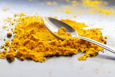 Masada kaşık olan sarı köri tozu yığını. Baharat. Kümes hayvanları baharatı