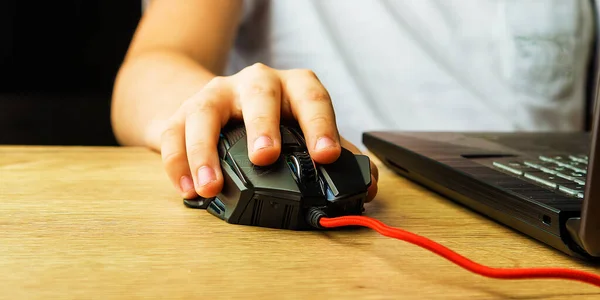 Children\'s hand is on a computer mouse. The hand guides learning with technology. Distance learning