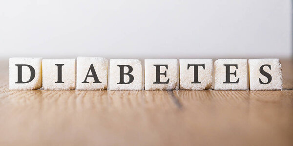 Кубики сахара с английским словом DIABETES написаны на квадратных блоках. Продвижение более здоровой диеты. Медицинская и медицинская концепция.