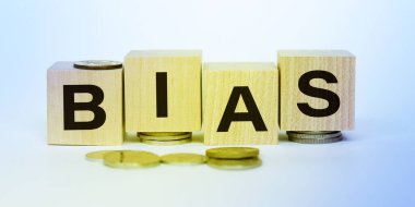 Bozuk paralı tahta küpler ve beyaz arka planda BIAS kelimesi. Vergi, vergi ve ücretlerin artırılması kavramı