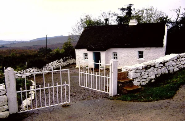 ヨーロッパ 北アイルランド 典型的な白塗りの茅葺き屋根のカントリーコテージ — ストック写真