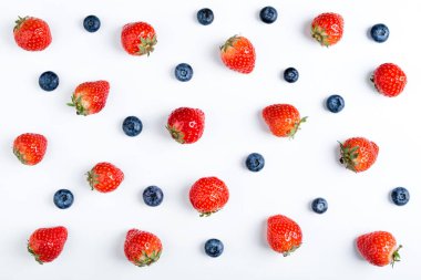 Çilek ve böğürtlenli beyaz arka planda, üstten görünüm. Çilek deseni, düz yatıyordu. Çilek ve beyaz arka plan üzerinde izole yaban mersini. Yaratıcı yiyecekler kavramı