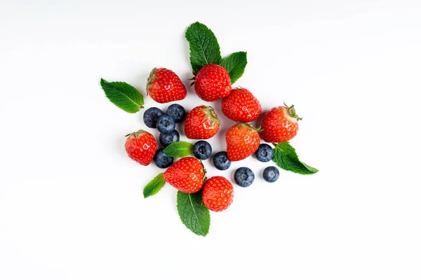 白い背景に 上面に新鮮な果実 イチゴ ブルーベリー ミントの葉 フラット レイアウト — ストック写真