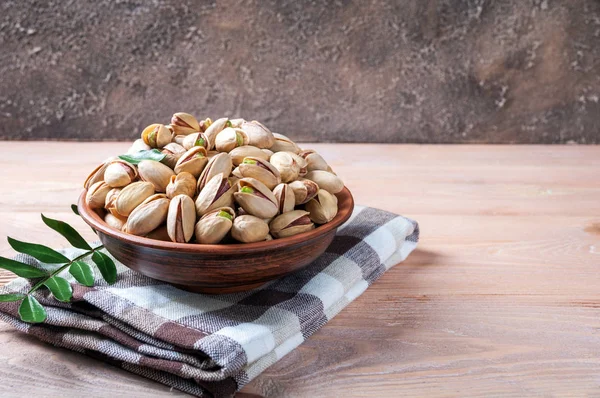Nueces de pistacho en tazón. Pistacho con hojas. Comida saludable, aperitivos, comida vegetariana —  Fotos de Stock