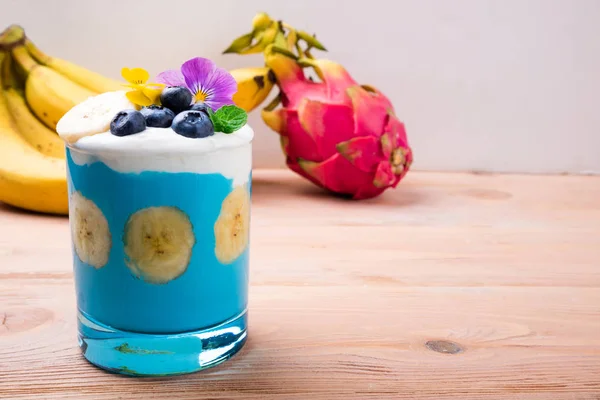 Frisk Smoothie Med Banan Frukt Blåbär Och Blommor Trä Bakgrund — Stockfoto