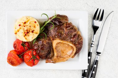Hazırlanan sığır eti biftek osso bucco patates püresi ve domates beyaz tablo ile. Üstten görünüm
