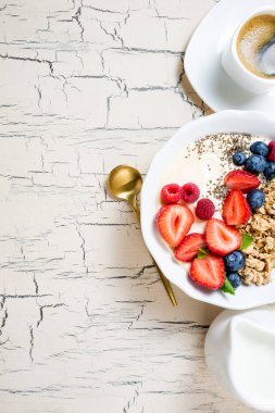 Granola çilek, yoğurt ve kahve kahvaltı için. Çilek, yaban mersini ve sağlıklı beslenme için ahududu ile tahıl yulaf. Kopya alanı ile üstten görünüm