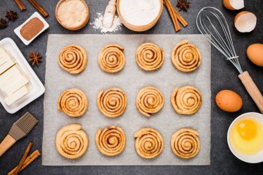Pişirme Cinnabon. Geleneksel Danimarka şekerli tatlı çörekler için hazırlık çiğ hamur. Tarçınlı çörek düz için malzemeler pişirme yatıyordu. Üstten görünüm