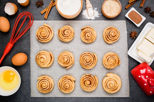 Pişirme Cinnabon. Geleneksel Danimarka şekerli tatlı çörekler için hazırlık çiğ hamur. Tarçınlı çörek düz için malzemeler pişirme yatıyordu. Üstten görünüm